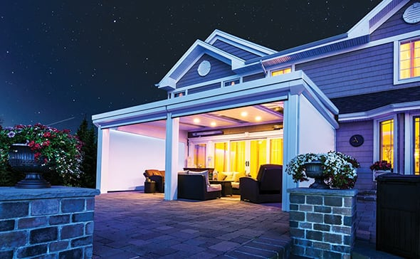 A Back Patio at Night with the Outdoor Screen Open and Recessed LED Lights Illuminating the Room